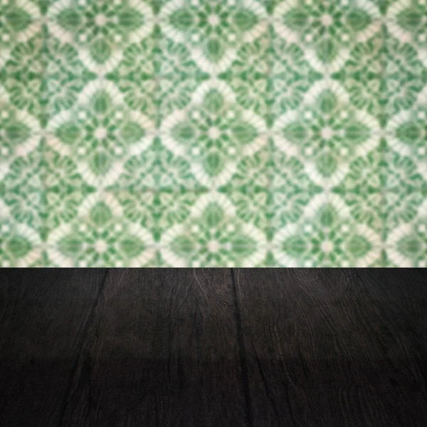 Wood table top and blur vintage ceramic tile pattern wall — Stock Photo, Image