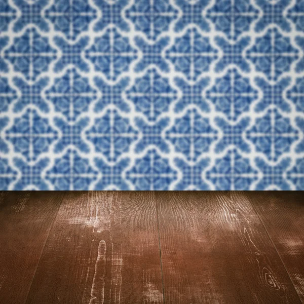 Wood table top and blur vintage ceramic tile pattern wall — Stock Photo, Image