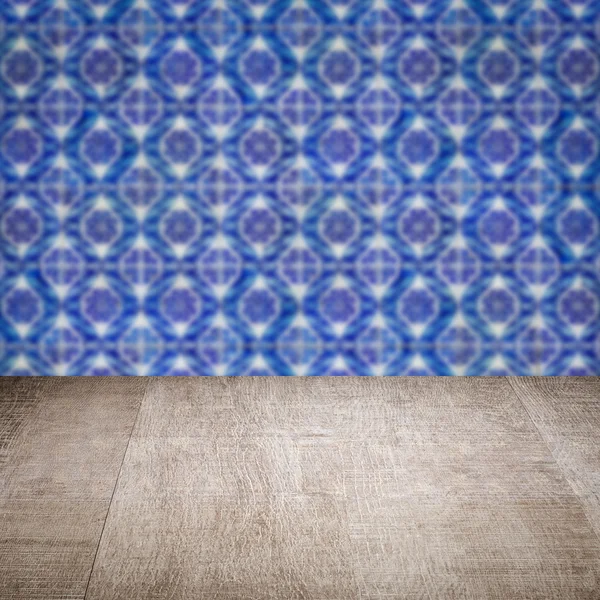 Wood table top and blur vintage ceramic tile pattern wall — Stock Photo, Image