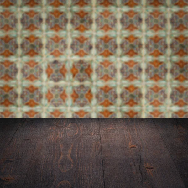 Wood table top and blur vintage ceramic tile pattern wall — Stock Photo, Image