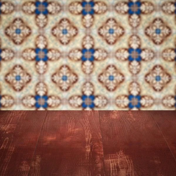 Wood table top and blur vintage ceramic tile pattern wall — Stock Photo, Image