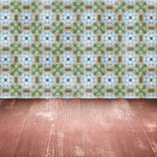 Wood table top and blur vintage ceramic tile pattern wall — Stock Photo, Image