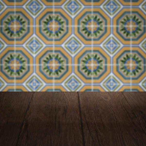 Wood table top and blur vintage ceramic tile pattern wall — Stock Photo, Image