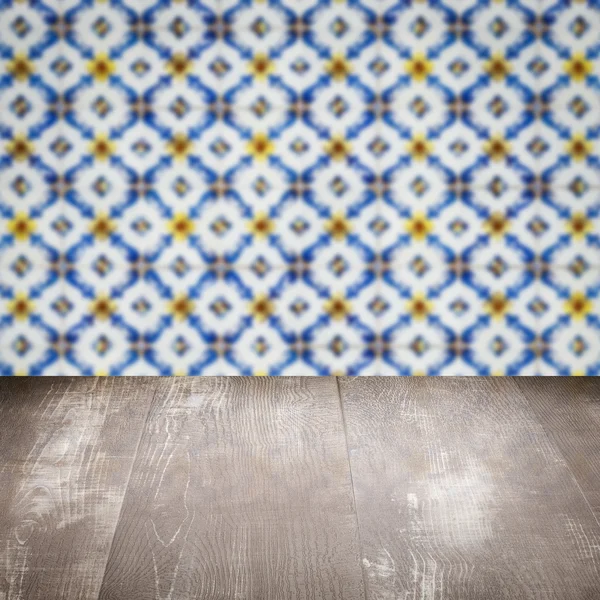 Wood table top and blur vintage ceramic tile pattern wall — Stock Photo, Image