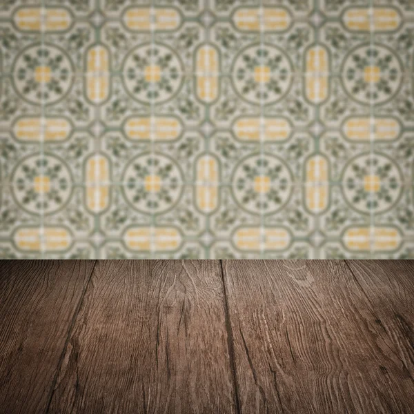 Wood table top and blur vintage ceramic tile pattern wall — Stock Photo, Image