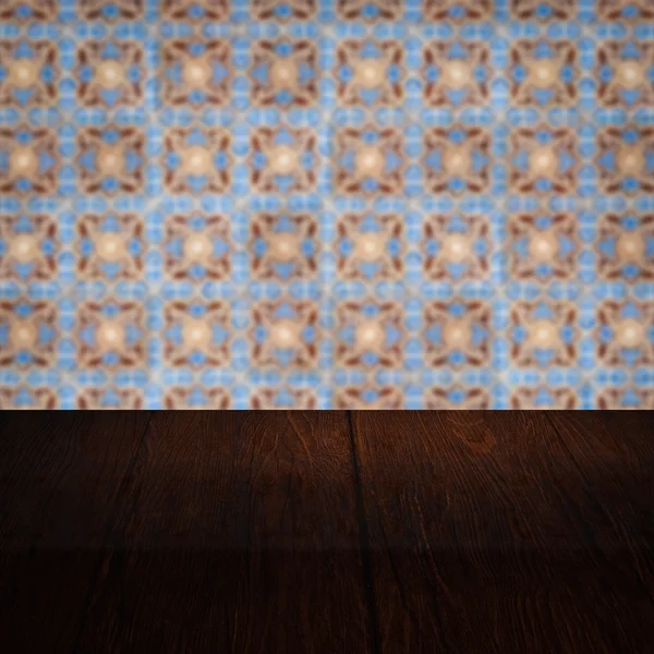 Wood table top and blur vintage ceramic tile pattern wall — Stock Photo, Image