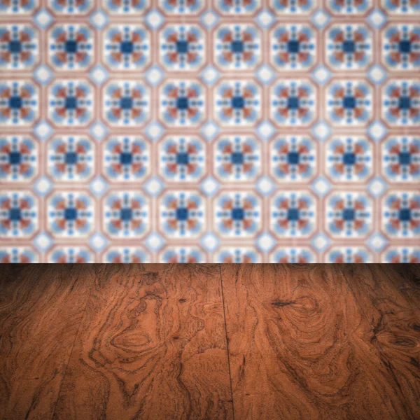 Wood table top and blur vintage ceramic tile pattern wall — Stock Photo, Image