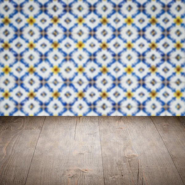 Wood table top and blur vintage ceramic tile pattern wall — Stock Photo, Image