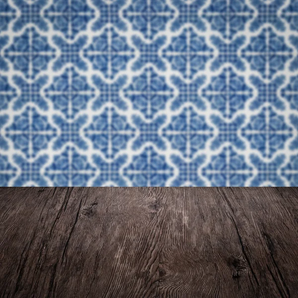 Wood table top and blur vintage ceramic tile pattern wall — Stock Photo, Image