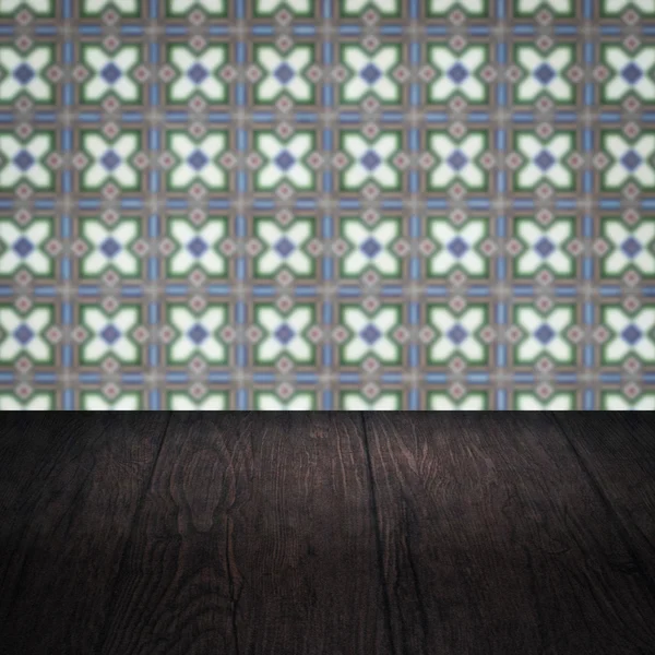 Wood table top and blur vintage ceramic tile pattern wall — Stock Photo, Image