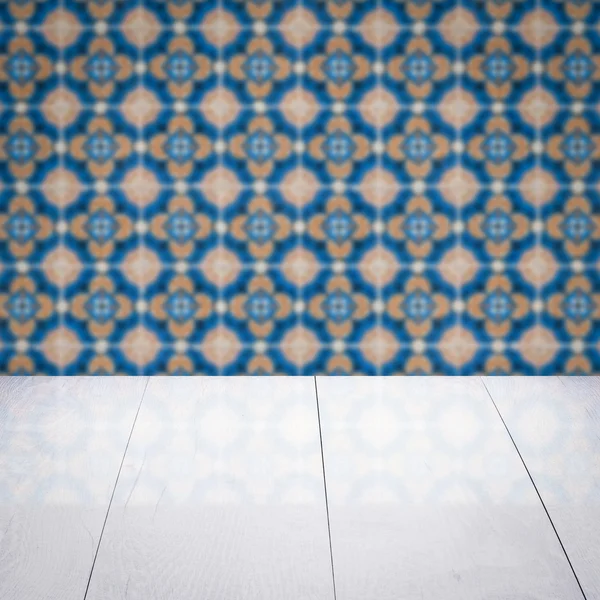 Wood table top and blur vintage ceramic tile pattern wall — Stock Photo, Image