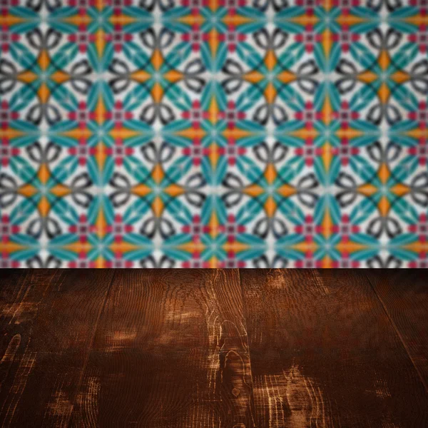 Wood table top and blur vintage ceramic tile pattern wall — Stock Photo, Image