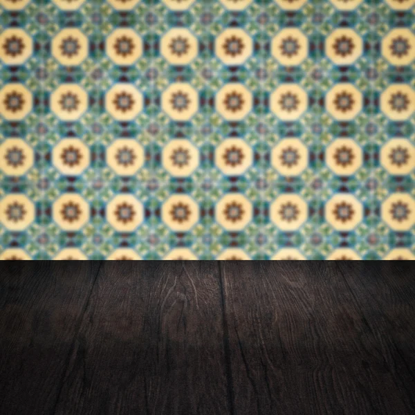 Wood table top and blur vintage ceramic tile pattern wall — Stock Photo, Image