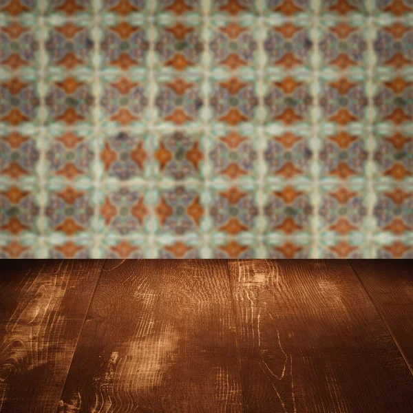 Wood table top and blur vintage ceramic tile pattern wall — Stock Photo, Image