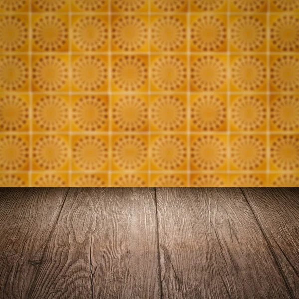 Wood table top and blur vintage ceramic tile pattern wall — Stock Photo, Image