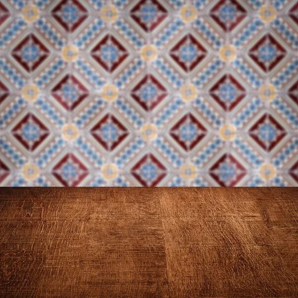 Wood table top and blur vintage ceramic tile pattern wall — Stock Photo, Image