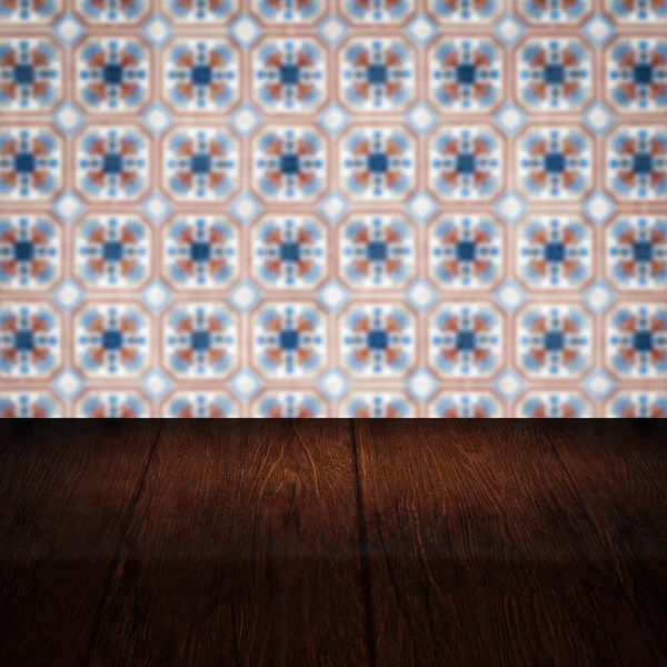 Wood table top and blur vintage ceramic tile pattern wall — Stock Photo, Image