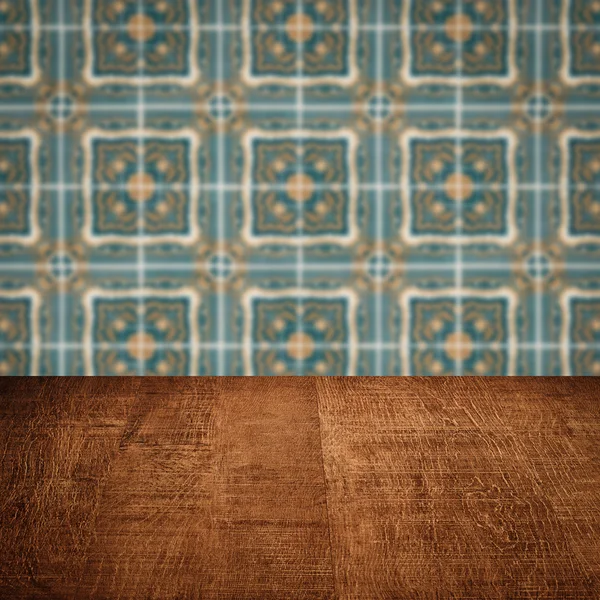 Wood table top and blur vintage ceramic tile pattern wall — Stock Photo, Image