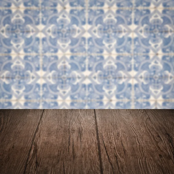 Wood table top and blur vintage ceramic tile pattern wall — Stock Photo, Image