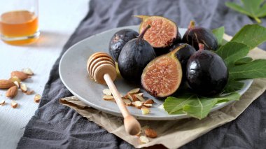 Taze Siyah Görev incirlerinden oluşan kırsal bir hayat. Bazıları canlı kırmızı etlerini ortaya çıkarmak için ortadan ikiye bölünmüş..