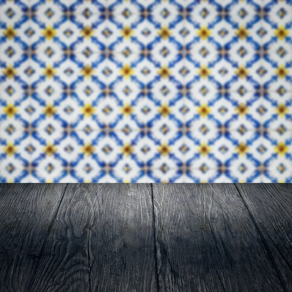 Wood table top and blur vintage ceramic tile pattern wall — Stock Photo, Image