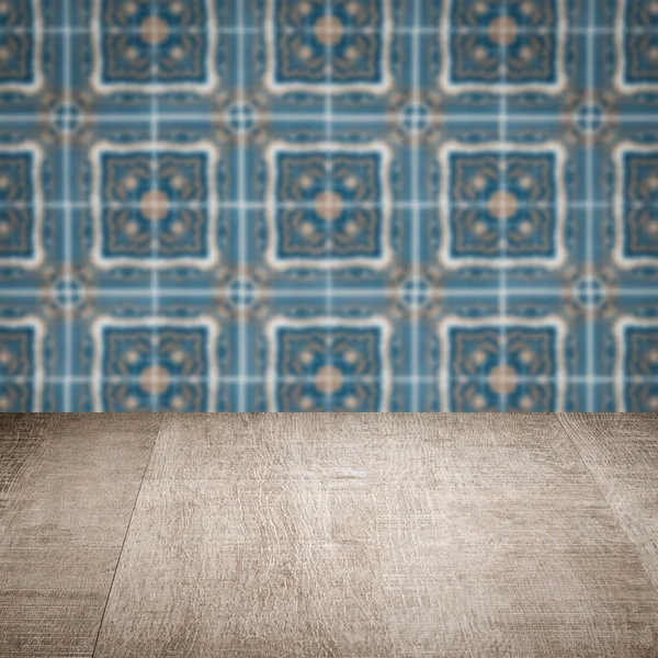 Wood table top and blur vintage ceramic tile pattern wall — Stock Photo, Image