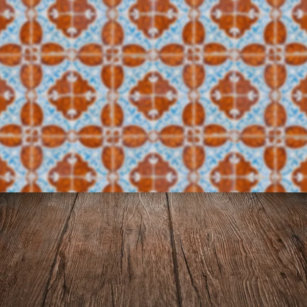 Wood table top and blur vintage ceramic tile pattern wall — Stock Photo, Image