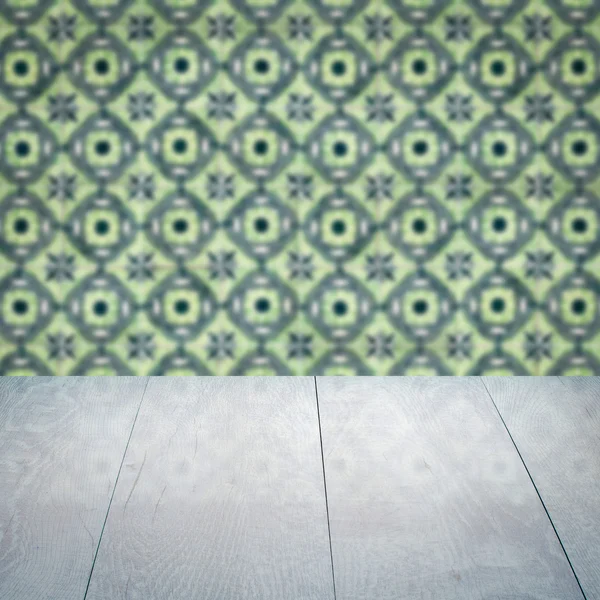 Wood table top and blur vintage ceramic tile pattern wall — Stock Photo, Image