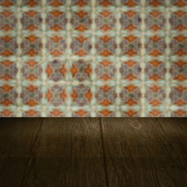 Wood table top and blur vintage ceramic tile pattern wall — Stock Photo, Image