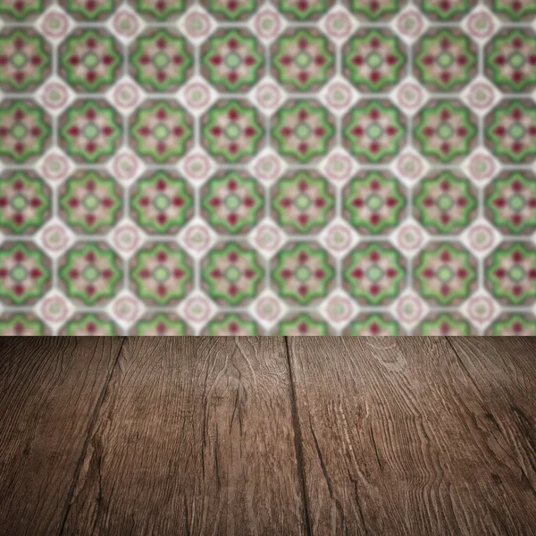 Wood table top and blur vintage ceramic tile pattern wall — Stock Photo, Image