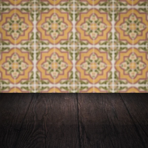 Wood table top and blur vintage ceramic tile pattern wall — Stock Photo, Image