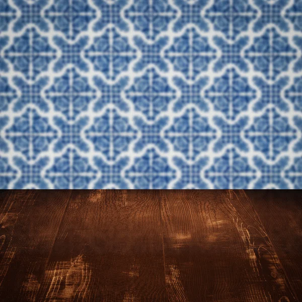 Wood table top and blur vintage ceramic tile pattern wall — Stock Photo, Image