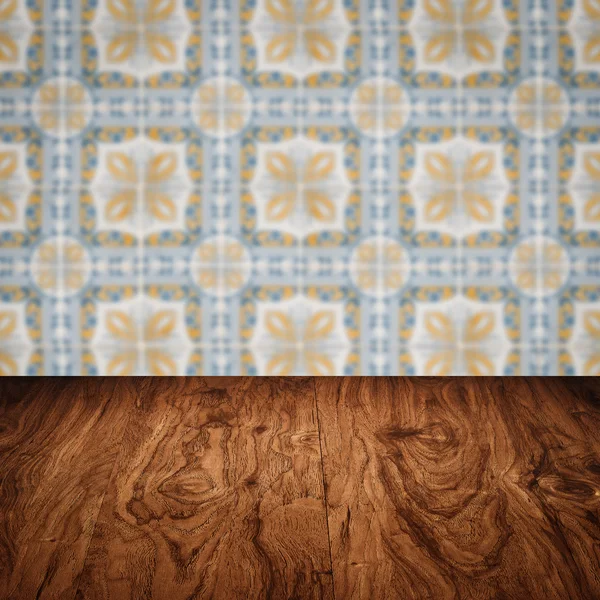 Wood table top and blur vintage ceramic tile pattern wall — Stock Photo, Image