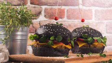 Lezzetli ızgara vejetaryen burger, mercimek, kuru domates ve ahşap tezgahta siyah ekmek..