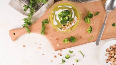 Mutfak tezgahında cam bir kasede brokoli çorbası, sapları dilimlenmiş..