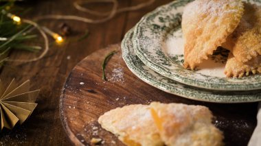 Taze pişmiş bir ekşi mayalı ekmek çizgili keten bir bezin üzerindeki tel askıda duruyor. Altın-kahverengi kabuk un tozlama ve karmaşık çizgiler altında yumuşak, sıcak ışık altında.