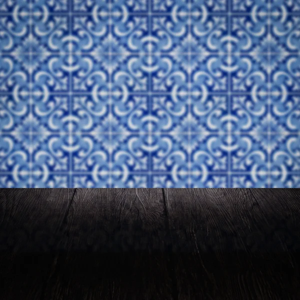 Wood table top and blur vintage ceramic tile pattern wall — Stock Photo, Image