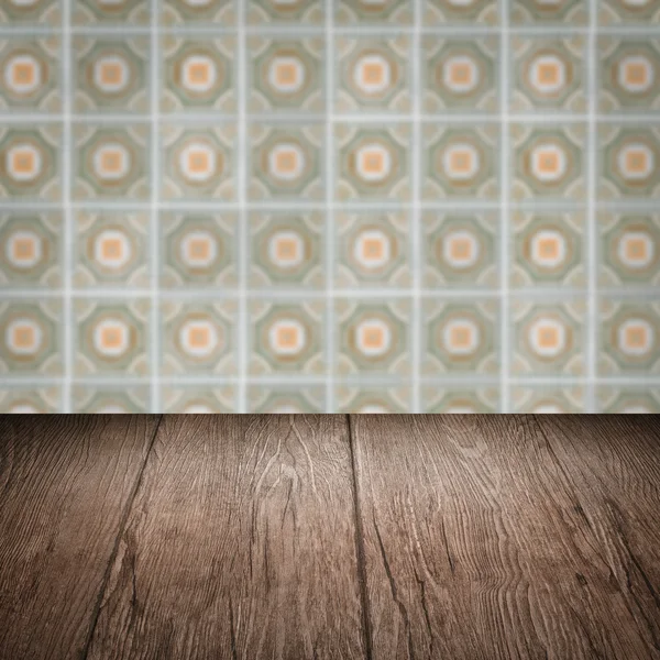 Wood table top and blur vintage ceramic tile pattern wall — Stock Photo, Image