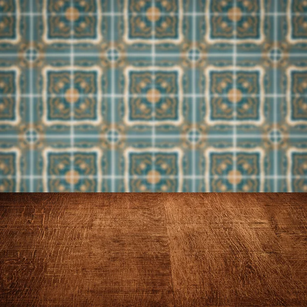 Wood table top and blur vintage ceramic tile pattern wall — Stock Photo, Image