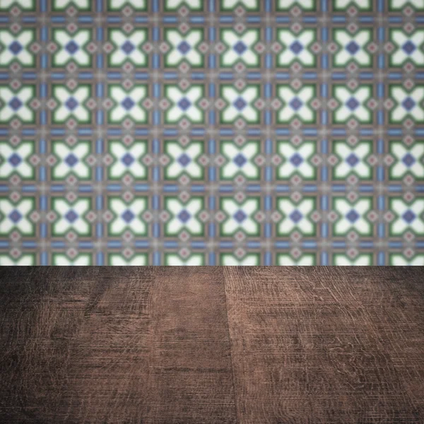 Wood table top and blur vintage ceramic tile pattern wall — Stock Photo, Image