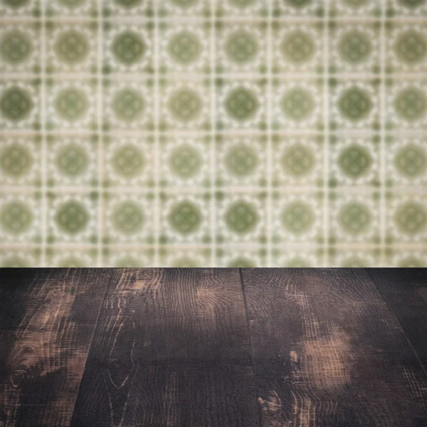 Wood table top and blur vintage ceramic tile pattern wall — Stock Photo, Image