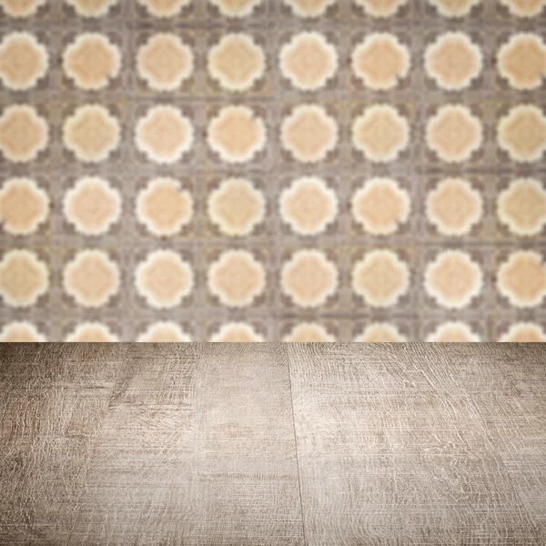 Wood table top and blur vintage ceramic tile pattern wall — Stock Photo, Image