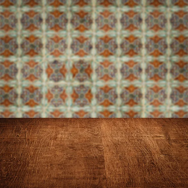 Wood table top and blur vintage ceramic tile pattern wall — Stock Photo, Image