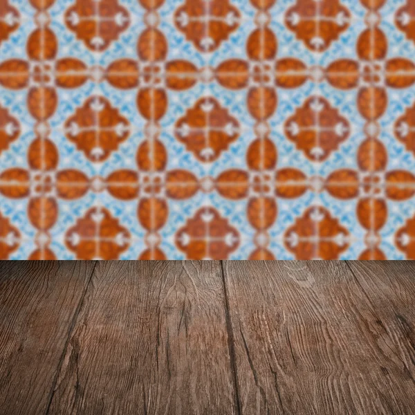 Wood table top and blur vintage ceramic tile pattern wall — Stock Photo, Image