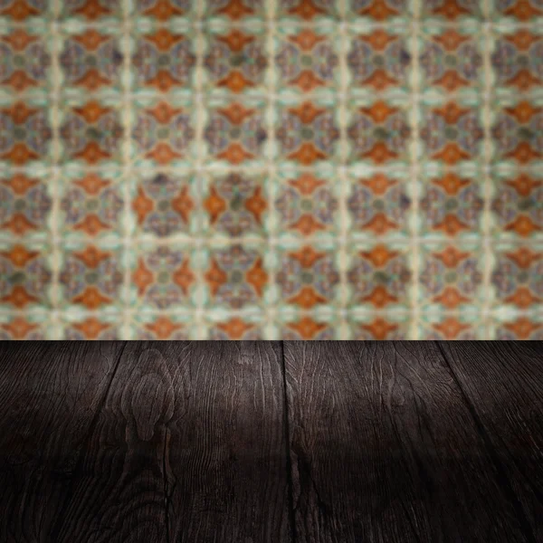 Wood table top and blur vintage ceramic tile pattern wall — Stock Photo, Image