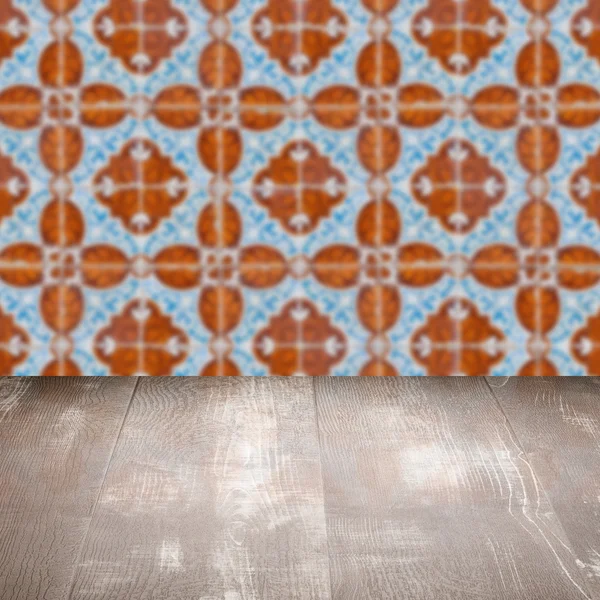 Wood table top and blur vintage ceramic tile pattern wall — Stock Photo, Image