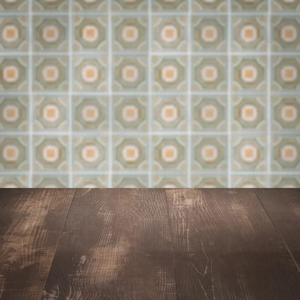 Houten tafelblad en vervagen vintage ceramiektegel patroon muur — Stockfoto