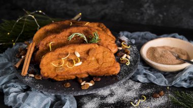 Traditional Christmas Rabanadas with lemon zest, raisins, pine nuts and cinnamon. Spanish Torrijas or french toasts close up on the countertop