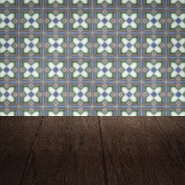 Wood table top and blur vintage ceramic tile pattern wall — Stock Photo, Image