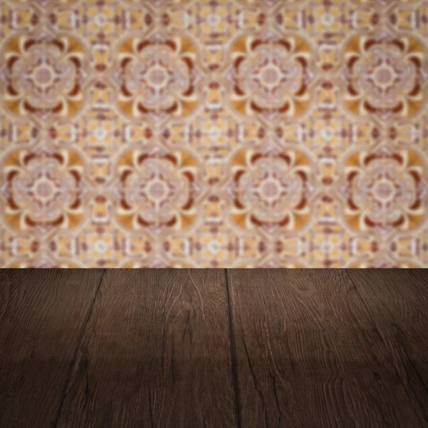 Wood table top and blur vintage ceramic tile pattern wall — Stock Photo, Image